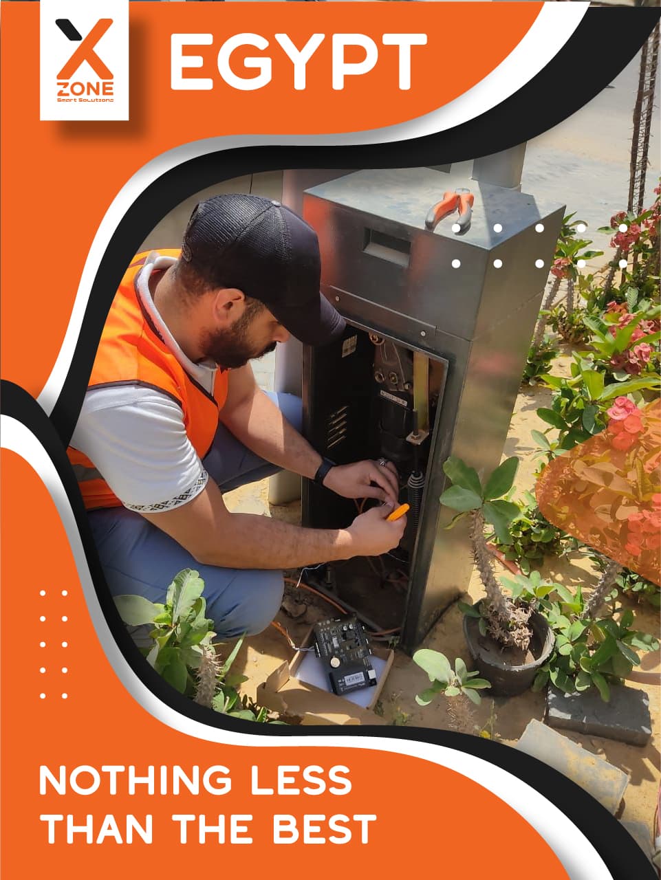Technician in an orange safety vest servicing an outdoor electrical control box in Egypt.